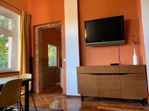 uma sala de estar com uma televisão de ecrã plano na parede em Villa 25 em Gartz an der Oder