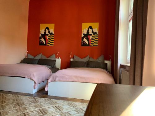 two beds in a room with a red wall at Villa 25 in Gartz an der Oder