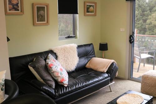 a black leather couch in a living room at Ulverstone River Retreat in Ulverstone