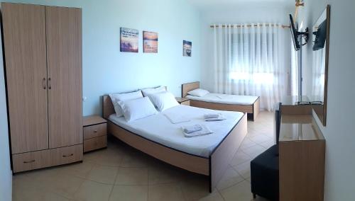 ein Schlafzimmer mit einem großen Bett und ein Zimmer mit Aermott in der Unterkunft Ilion Hotel in Dhërmi
