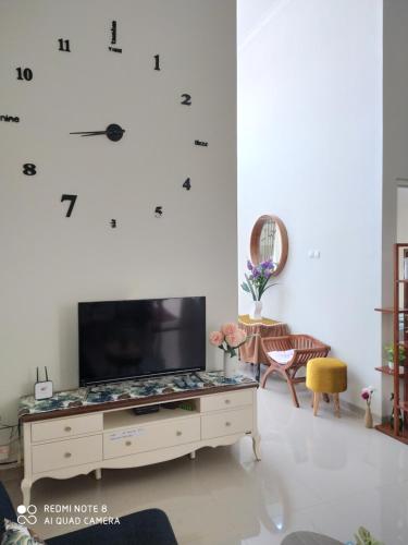 a living room with a large television on a white wall at Alysahouse - 2 Bedrooms, Dekat JTP3 in Batu