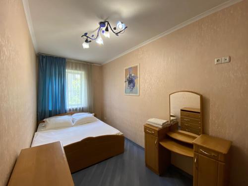 ein kleines Schlafzimmer mit einem Bett und einem Spiegel in der Unterkunft Comfy Apartment Most City Area in Dnipro