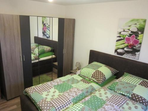 - une chambre avec 2 lits et un miroir dans l'établissement Ferienwohnung Sonja Sinsheim, à Sinsheim