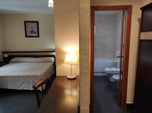 
a hotel room with a toilet and a bed at Hotel Prado Real in Soto del Real
