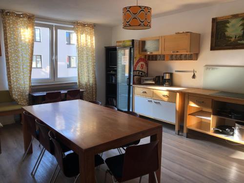 uma cozinha com uma mesa de madeira e uma sala de jantar em Weltempfänger Backpacker Hostel em Colónia