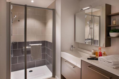 a bathroom with a shower and a sink at Domitys - Galilée in Cergy