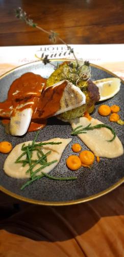 a plate of food with meat and vegetables on a table at HOTEL de la Truite & SPA Le petit Nautilus in Le Pont