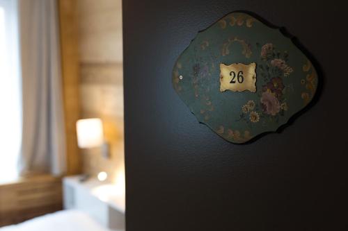 a clock on the wall of a bedroom at Hôtel Restaurant l'Aubergade in Gérardmer
