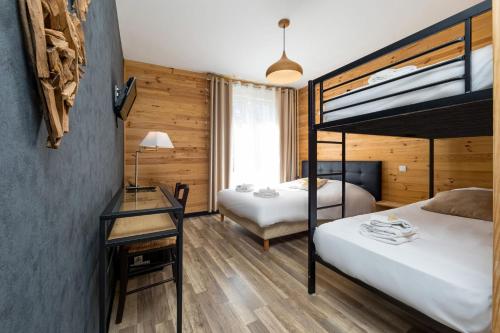 a bedroom with two bunk beds and a desk at Hôtel Restaurant l'Aubergade in Gérardmer