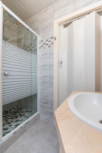 a bathroom with a shower and a sink and a tub at Hôtel Restaurant l'Aubergade in Gérardmer