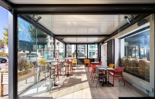 a restaurant with a balcony with tables and chairs at Hôtel Restaurant l'Aubergade in Gérardmer