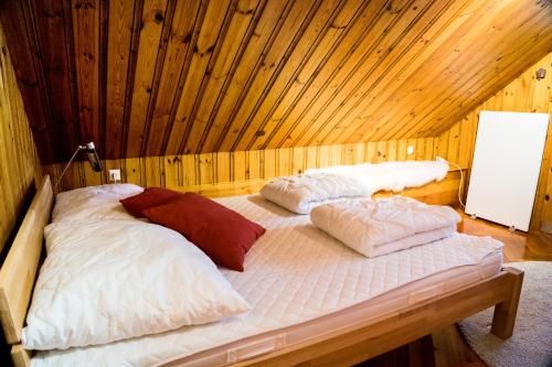two beds in a room with a wooden ceiling at Chalet am See in Keutschach am See