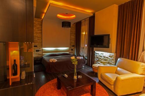 a living room with a couch and a bed at Hotel Petrus in Paraćin