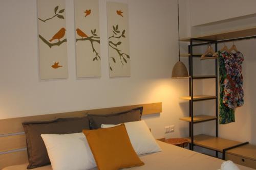 a bedroom with a bed and some birds on the wall at House Ekton in Pefkari
