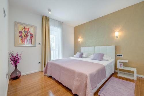 Un dormitorio con una cama y un jarrón de flores. en Apartment Rex Exclusive, en Split