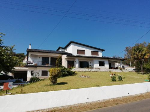 a white house with a large yard in front of it at BB Silvercoast Casa das Flores in Santa Catarina