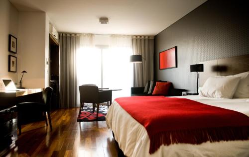 um quarto de hotel com uma cama com um cobertor vermelho em Fierro Hotel Buenos Aires em Buenos Aires