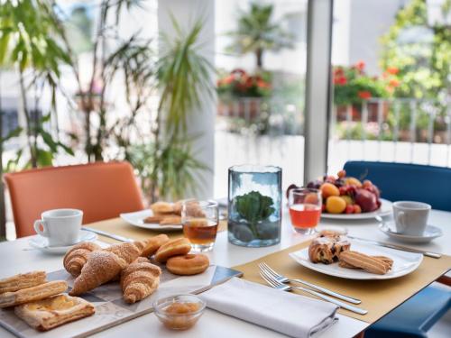 a table with plates of pastries and fruit on it at Hotel Colle Del Sole in Alberobello