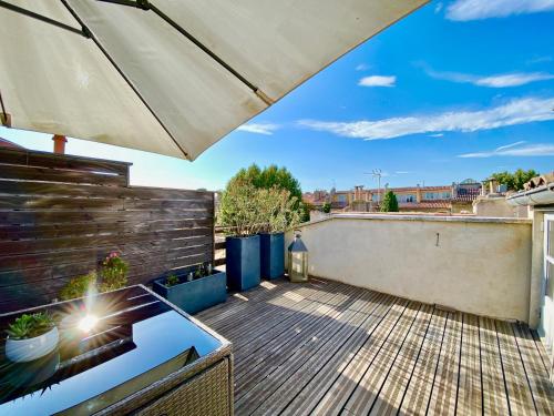 une terrasse avec un parasol dans l'établissement Èrsextius, LGLL1, Aix-en-Provence, à Aix-en-Provence