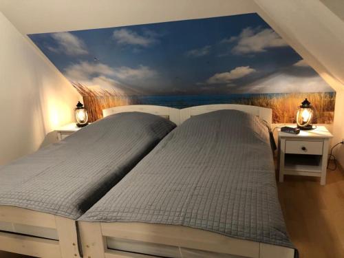 2 camas en un dormitorio con una pintura en la pared en Bi Grete tohuus en Dornum
