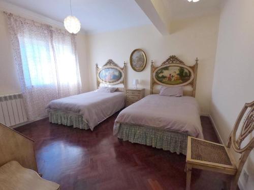 a bedroom with two beds and a mirror and a window at AYAMI Villa in Setúbal