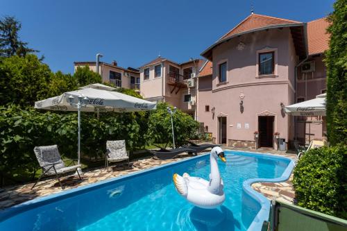 a swimming pool with a swan in the water at Illés Hotel in Szeged