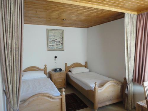 2 camas en una habitación pequeña con ventana en Haus Vogel-Nest, en Reit im Winkl