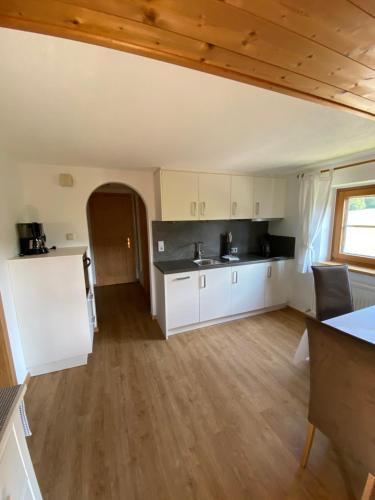a large kitchen with white cabinets and a table at Hof Oberhaus in Kitzbühel
