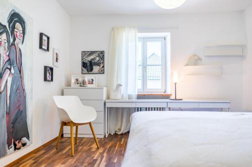 ein Schlafzimmer mit einem Bett, einem Schreibtisch und einem Stuhl in der Unterkunft Im Schneewinkl in Schönau am Königssee