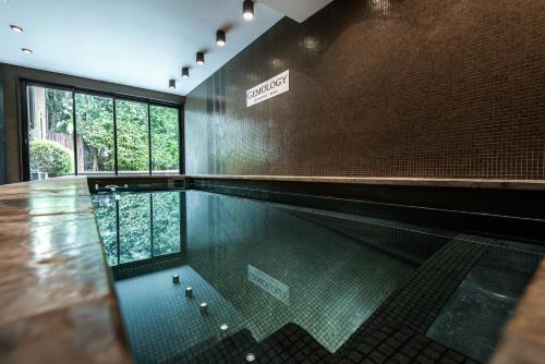 a swimming pool with a sign on the wall at Hôtel du Château & Spa - Teritoria in Carcassonne