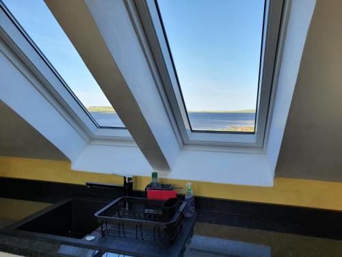 a bathroom with a skylight and a sink with a window at Lochview in Swannay