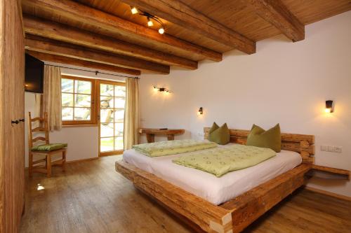 a bedroom with a large bed in a room with wooden ceilings at Andis Almdorf in Sölden