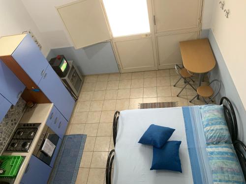 an overhead view of a kitchen with a bed with blue pillows at Loft Rapisardi in Catania