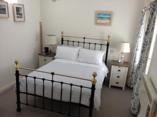 a bedroom with a black and white bed and two lamps at Trenance House in Helston