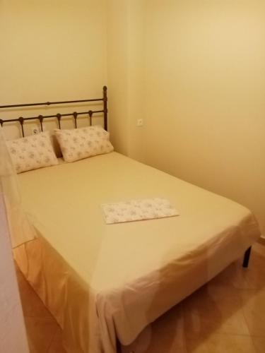 a small bedroom with a bed with white sheets and pillows at Dolphins DreamHouse in Agios Ioannis Pelio