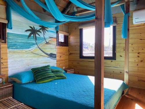 a bedroom with a bed in a wooden cabin at caribe in Punta Del Diablo