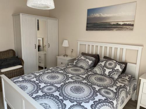 a bedroom with a bed with a blue and white comforter at Apartamenty AMALIA in Rewal