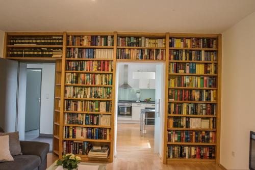 a living room with four book shelves filled with books at Ferienwohnung Roos in Klüsserath