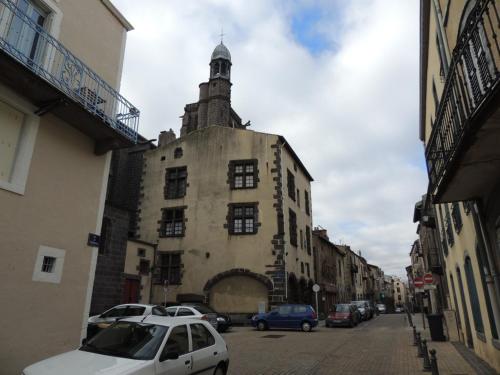 an old building with a clock tower on a street at Monfs Apparts Clermont-Ferrand, pres de toute commodites in Clermont-Ferrand