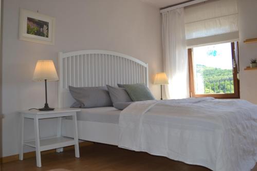een witte slaapkamer met een bed en een raam bij Ferienhaus AM ALTEN POSTHOF in Lieser