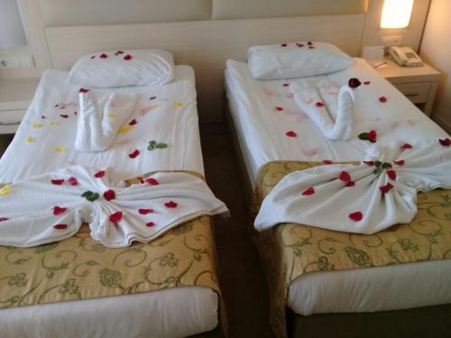 two beds with white towels with hearts on them at MG Moms Hotel in Kemer