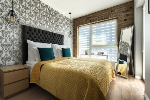 a bedroom with a large bed with blue pillows at Malta Apartament Parking by IMPERO in Poznań