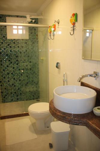 a bathroom with a sink and a toilet and a shower at Pousada Porto e Mar in Porto De Galinhas