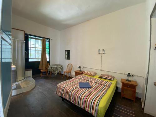 a bedroom with a bed and a table and chairs at Pension La Cubana in Santa Cruz de la Palma