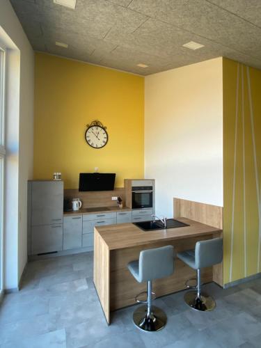 a kitchen with a counter and a clock on the wall at Ferienwohnungen Eifelausblick in Hümmel