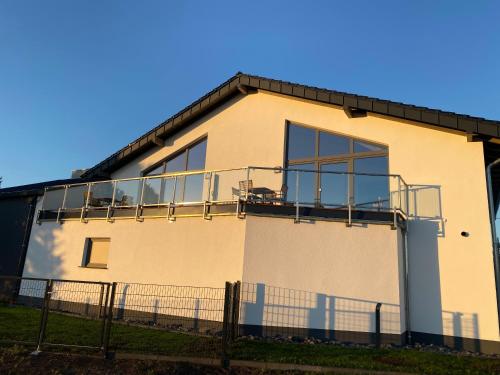 a building with a balcony on the side of it at Ferienwohnungen Eifelausblick in Hümmel