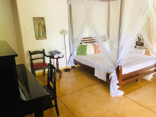 1 dormitorio con 1 cama con mosquitera en FireMoonGarden by Peacock Villa en Mirissa