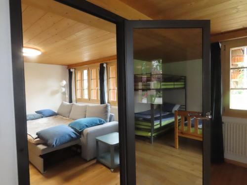 ein Wohnzimmer mit einem Sofa und einem Spiegel in der Unterkunft Holzhaus bei Interlaken in Goldswil