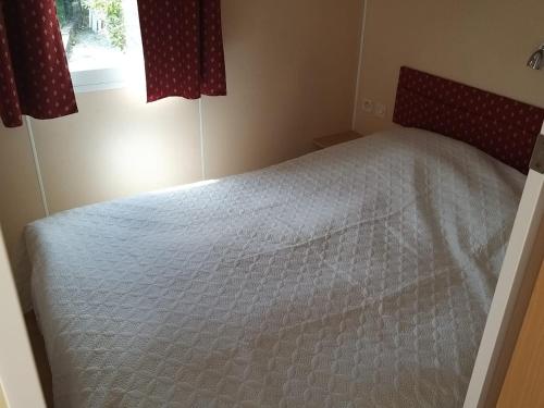 1 dormitorio con 1 cama blanca en una habitación con ventana en Mobile Home Etang II, en Chiddes