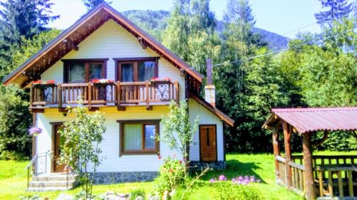 a small house with a balcony on top of it at Котедж "Хата край села" in Tatariv